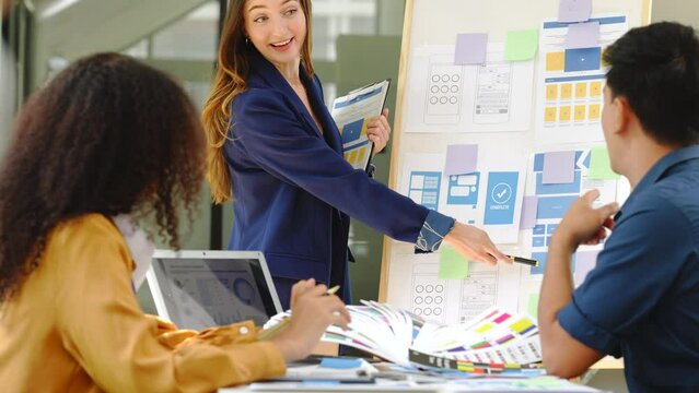 diverse team of professionals engaged in a website graphic design board meeting, sharing opinions on UX and UI design elements. Asian man, African American people, black, afro, caucasian female