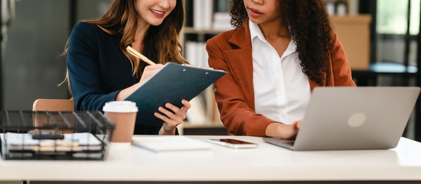 Two professional caucasian with african american businesswoman friends collaboration, working together at office, using laptop, Generally accepted audit standards, Earnings before interest and taxes