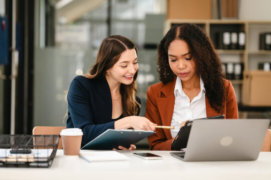 Two professional caucasian with african american businesswoman friends collaboration, working together at office, using laptop, Generally accepted audit standards, Earnings before interest and taxes