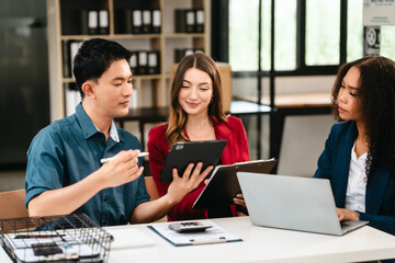 Diverse group of professionals engaging in discussion with laptop and clipboard, in bright office environment. qualified auditor report and opinion, asian people, african american, caucasian female