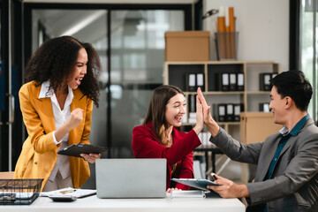 Diverse group of three professionals, two women and man, working together on design project around laptop. Product design team for industrial, working together, Asian man, African american people