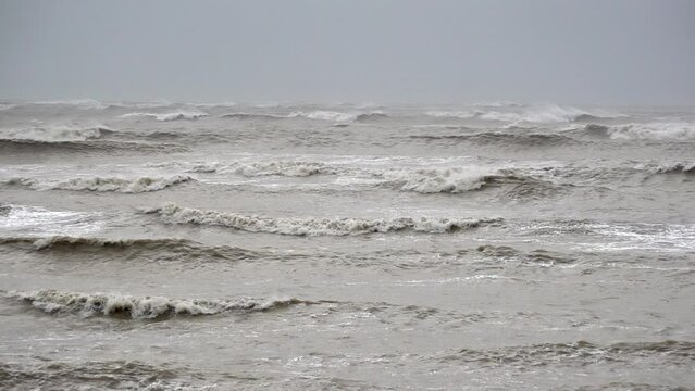 In slow motion dark, moody and threatening large waves are whipped up by strong winds as storm Ciar&aacute;n makes landfall and a bird struggles to fly.