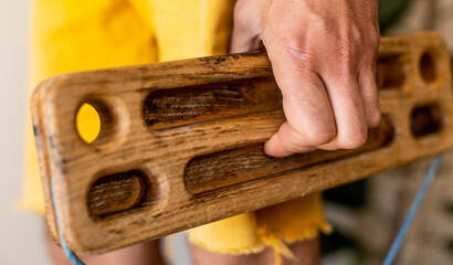 strong male hand of a rock climber holds a board for training finger strength. climbing workout at home. rock climber's hand close-up.