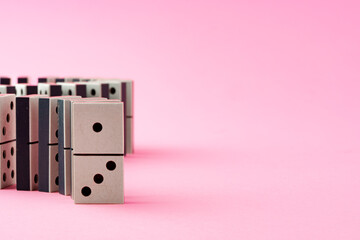 Row of domino tiles on pink studio background