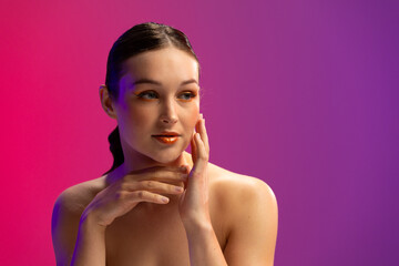 Caucasian woman wearing orange eye shadow and lip gloss on purple background, copy space