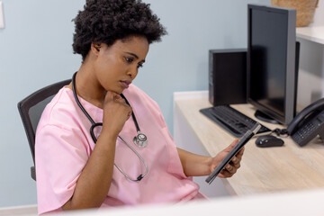 African american female doctor using tablet in hospital reception