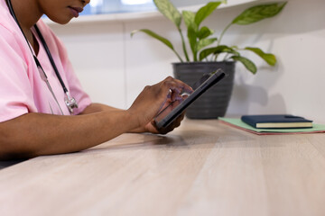 African american female doctor using tablet in hospital reception