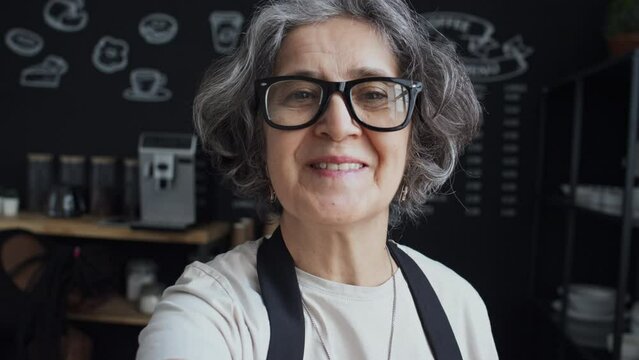 POV shot of elderly barista making vlog about her cafeteria, workplace and colleagues