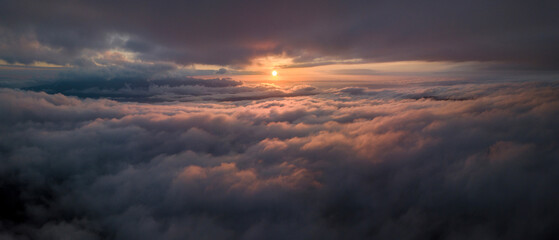 Panorama shot of colorful light of sunrise over rainforest mountains with fog and cloud inversion...