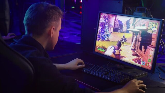 Streaming the competitive shooter video game tournament. Streaming the round of the third person shooter video game. Streamer killing the enemies in the multiplayer internet video game shooter.