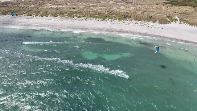 white sand beach aerial kite surfing 4k