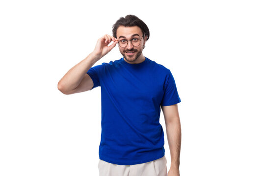 30 year old surprised european brutal guy with black hair and a beard in a blue t-shirt on a white background with copy space