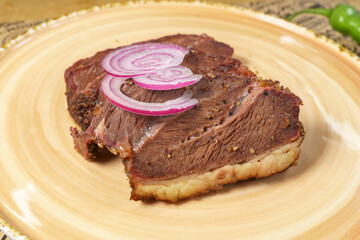 Juicy Steak with Caramelized Onions Served on a Gleaming White Plate. Selective focus