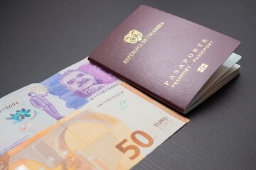 top shot of a 50 euro bill with a 50,000 colombian peso bill and the colombia passport showing the concept of international travel, currency exchange and economy