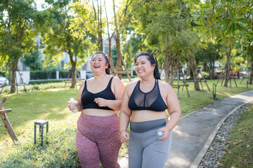 Happy plus size asian woman running in a park for health, wellness and outdoor exercise. Nature, sports and female athlete runner doing cardio workout in garden. Healthy Concept.