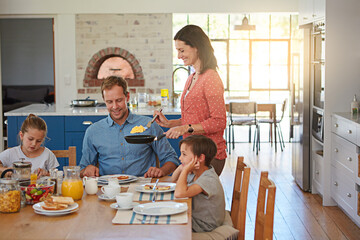 Breakfast, eggs and morning with a family in the dining room of their home together for health or...