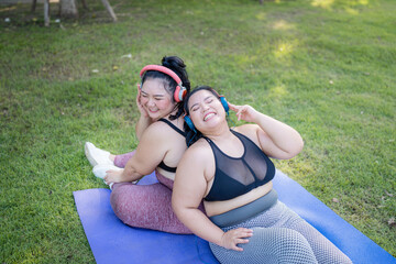 Happy plus size asian woman in fitness wear exercising in park for health, wellness and outdoor...