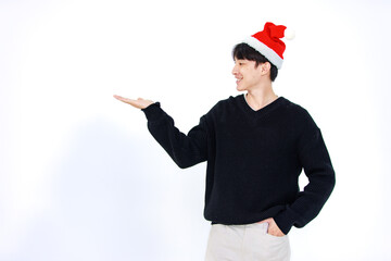Isolated cutout studio shot Asian cheerful male model wears red Santa Claus hat standing smiling holding hands presenting advertising products copyspace celebrated Christmas eve on white background