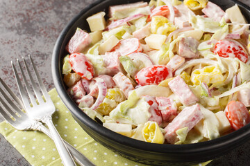 Italian American Grinder salad is made with lettuce, salami, ham, provolone, and fresh veggies closeup on the plate on the table. Horizontal
