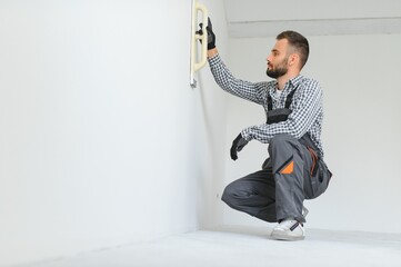 worker making repair in room.