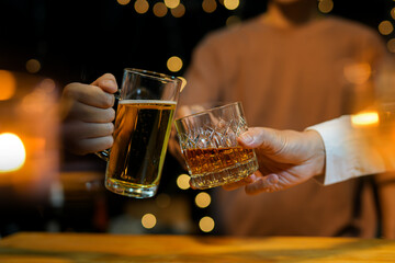 food and drink male friends are happy drinking beer and clinking glasses at a bar or pub.