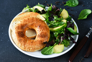 Bagel with cream cheese and salad for breakfast