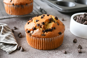 Muffin with chocolate chips on brown background. Sweet pastries.
