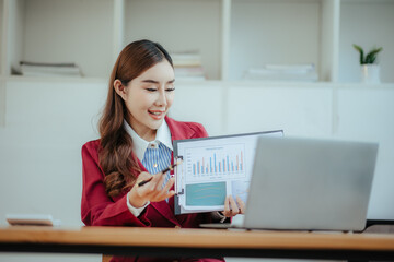 Portrait of a happy beautiful Asian businesswoman.
Working with a tablet in a company office