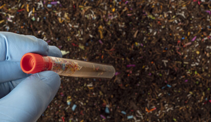 Microplastics in soil a test tube with soil sample - soil contaminated with mineral microplastics