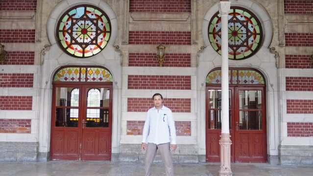 A strange man walks along the old railway station building in Istanbul. He stops and looks surprised
