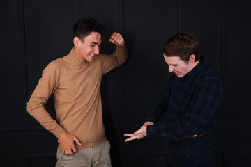 Two young attractive friends are arguing. Gay couple posing in the studio.