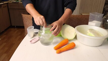 A man cooks sauerkraut at home. Preparing a brine. Dolves salt and sugar in water.
