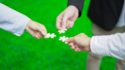Business hand-holding jigsaw puzzle With the cooperation of business people team joins together to...