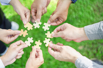 Fototapeta na wymiar Coworker's hand holding jigsaw puzzle With the cooperation of business people team joins together to campaign Environment, Society and Corporate Governance. Sustainable corporate social, environmental
