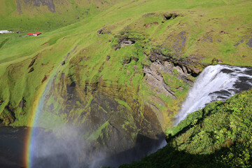 Rainbow at Skogafoss waterfall on the Skógá River from above in southern Iceland