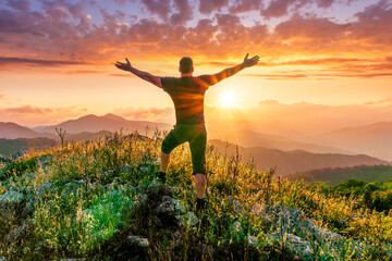 happy man watching amazing highland evening sunset, person delight with nature landscape - obrazy, fototapety, plakaty