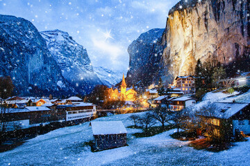 amazing touristic alpine village at night in winter with famous church and Staubbach waterfall  Lauterbrunnen  Switzerland  Europe