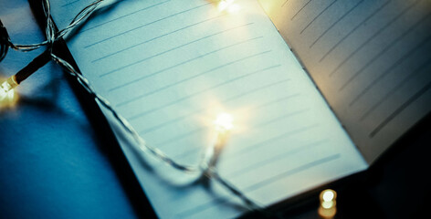 christmas lights on empty notebook page New Year resolutions