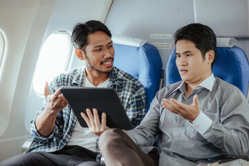 Two business men talking while boarding an airplane Smiling man holding hands