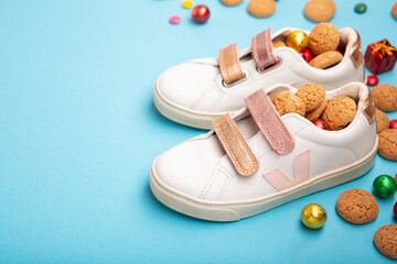 Saint Nicholas Day Winter Card. Holiday Sweets and Children's Shoes on Blue Background