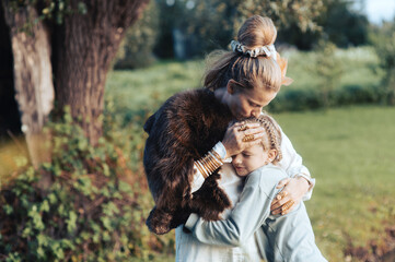 Naklejka na ściany i meble Young loving mother hugging her daughter, mom demonstrating unconditional love for child