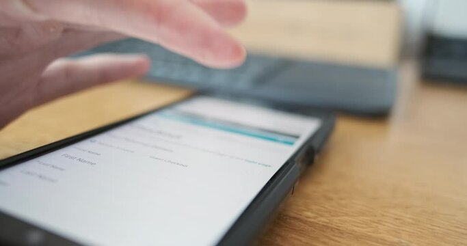 AMan's finger presses checkout button on smartphone screen. Side view, close-up. Concept of online payment, purchase, shopping.