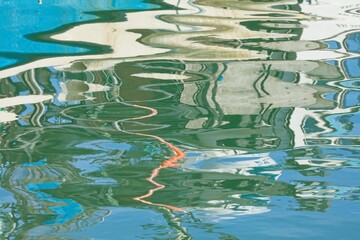 Reflections on sea surface of a boat with small waves.