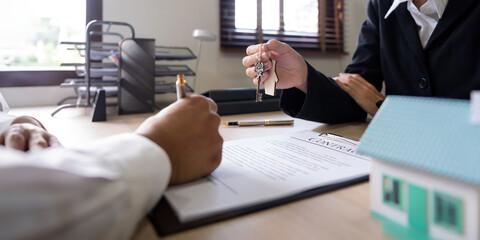 Real estate agents agree to purchase a home and give keys to clients at office. Concept agreement