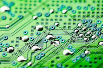 Electronic green printed circuit board with soldered copper contacts, holes, close-up, selective focus .
