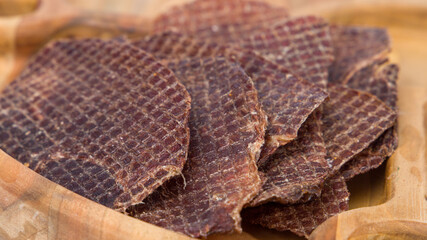 slices of dried beef on a wooden plate