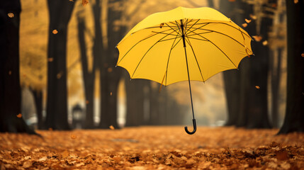 Yellow umbrella flying in a park in autumn - obrazy, fototapety, plakaty