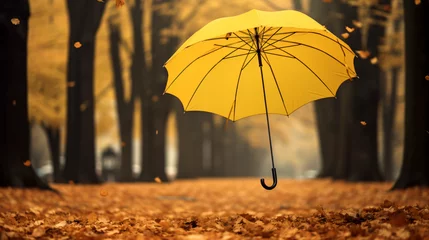 Fotobehang Yellow umbrella flying in a park in autumn © UsamaR