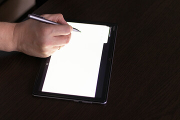 Business person working on wooden table Indoors, using tablet and stylos. Technology
