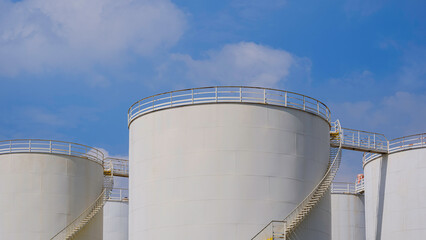 Group of white Storage Fuel Tanks in Oil Industrial area against cloud on blue sky background, low...